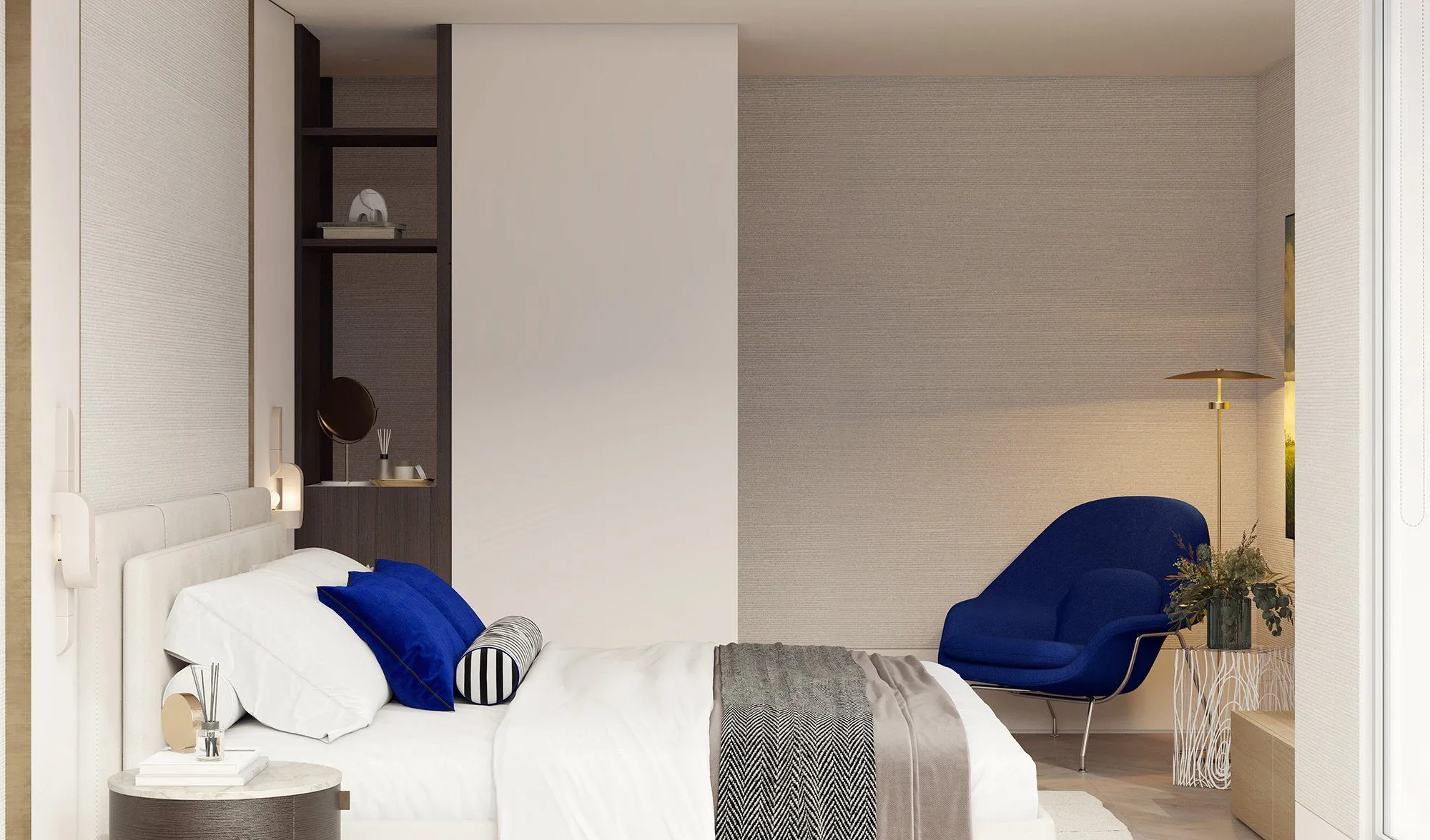 Bedside view of the beige bed with cobalt pillows and herringbone throw, cobalt Womb chair reading nook beyond — Minimalist Glamour - condo
