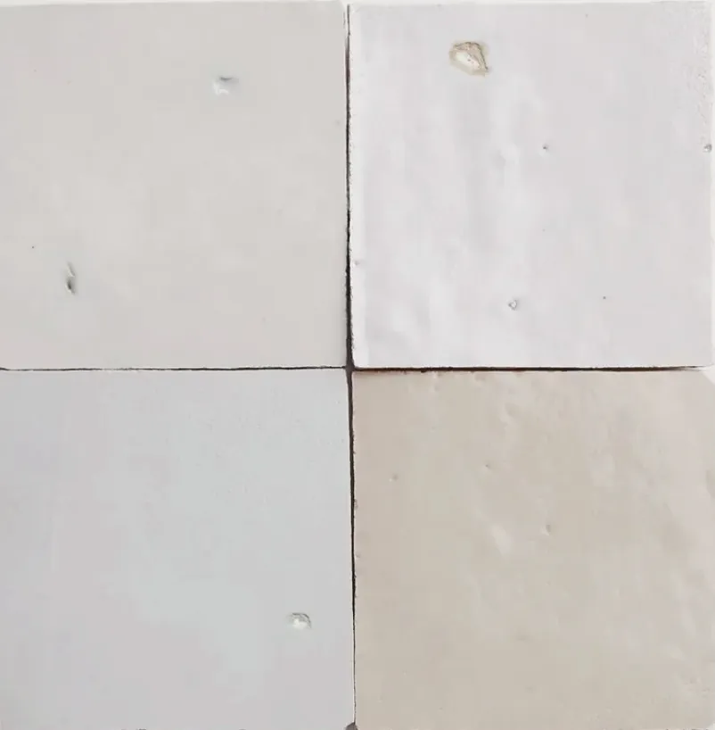 Close-up of handmade zellige tiles in soft whites and creams, each glazed square catching the light differently — The Aesthetic Era - Medical SPA interior design
